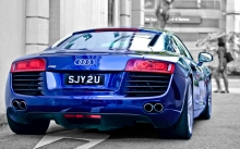 Блестящий синий Audi R8 на серых улицах мегаполиса
